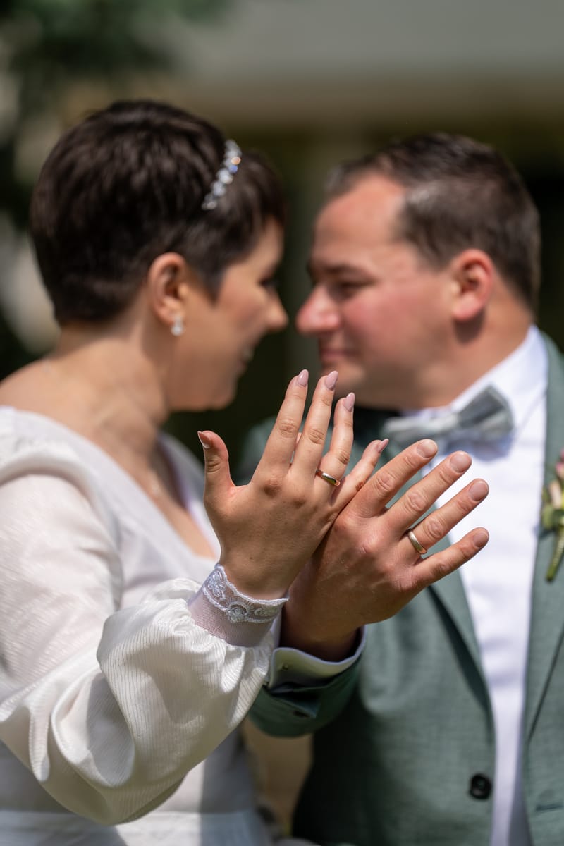 Brautpaar zeigt die Ringe